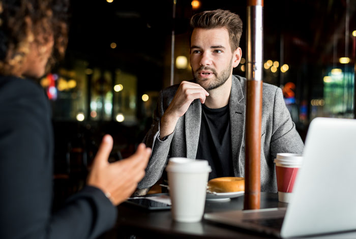 Man discussing big money projects confidently in a cafe setting during a business meeting. Man discussing big money projects confidently in a cafe setting during a business meeting.