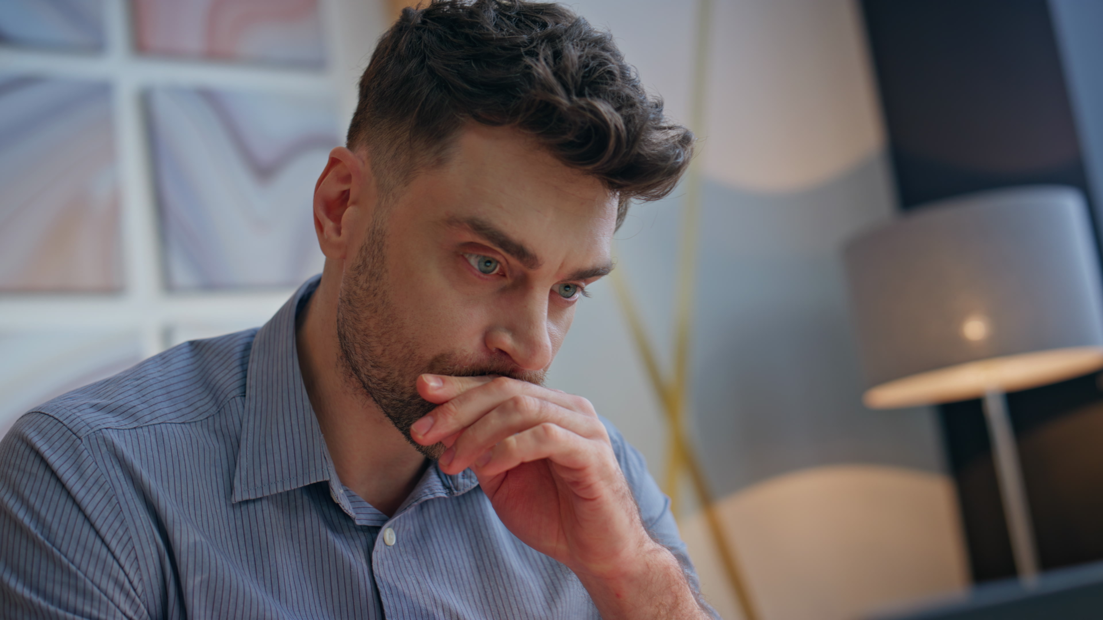 Worried man in a blue shirt contemplating emergency as he needs niece to watch his 11-year-old son at home. Worried man in a blue shirt contemplating emergency as he needs niece to watch his 11-year-old son at home.