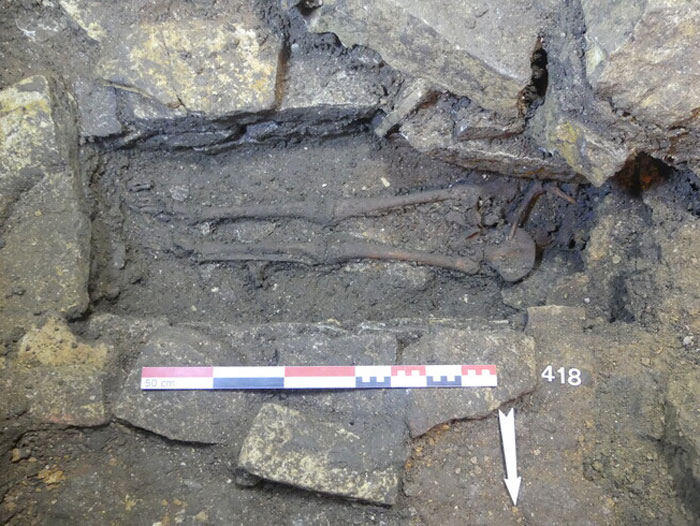 Skeleton remains found inside 400-year-old burial vault uncovered during church restoration works surrounded by stone debris.