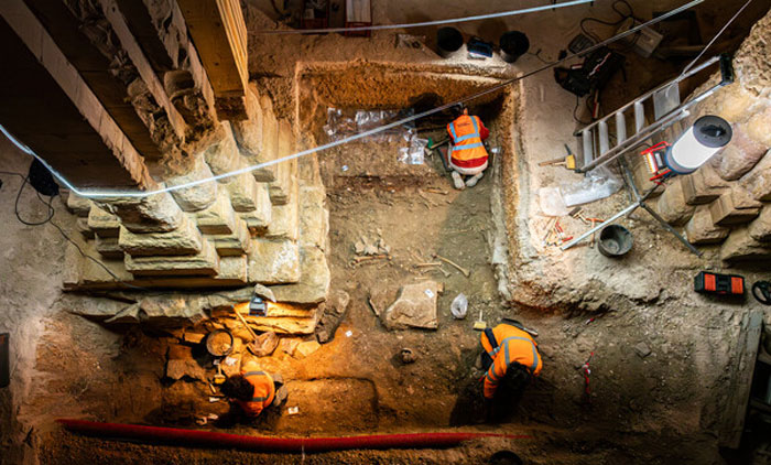 Archaeologists uncover a 400-year-old burial vault beneath church during restoration work with excavation tools and lighting. Archaeologists uncover a 400-year-old burial vault beneath church during restoration work with excavation tools and lighting.