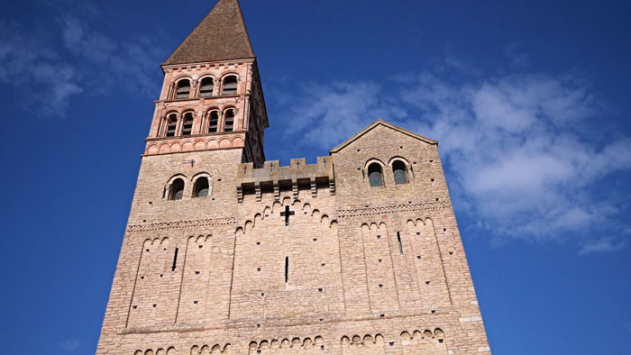 Historic stone church tower under blue sky where 400-year-old burial vault was discovered during restoration works. Historic stone church tower under blue sky where 400-year-old burial vault was discovered during restoration works.