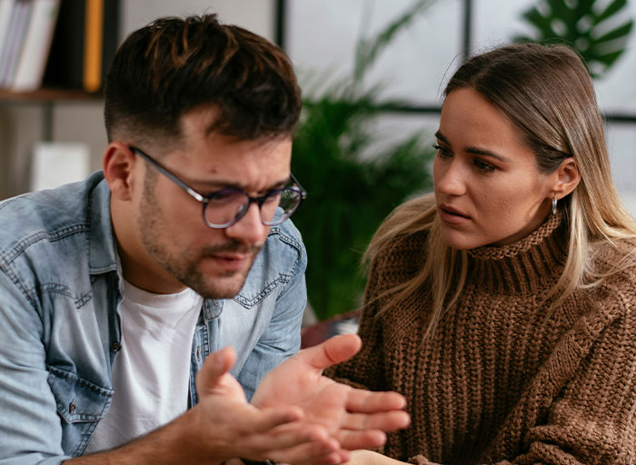Friend claims cat name for newborn while a concerned woman listens during a serious conversation at home. Friend claims cat name for newborn while a concerned woman listens during a serious conversation at home.