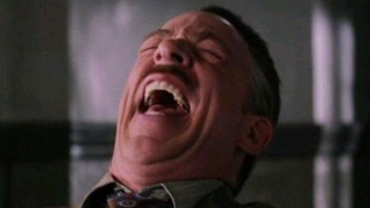 Man with mustache laughing loudly, capturing the essence of relatable memes for a much-needed laugh today.