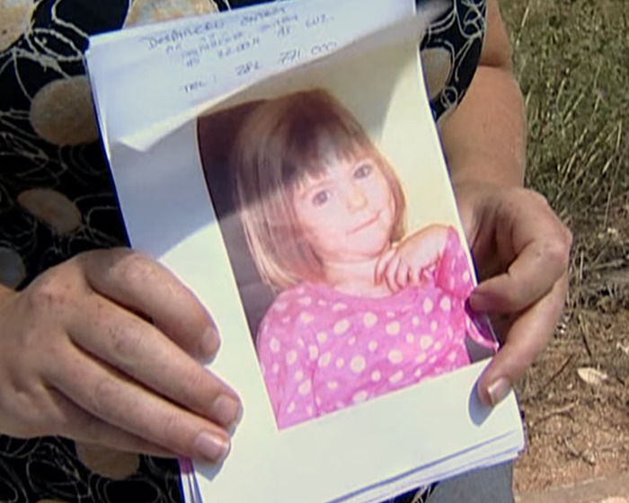 Person holding a photo of Madeleine McCann, related to mystery deepening after clothing and bones found in dig samples. Person holding a photo of Madeleine McCann, related to mystery deepening after clothing and bones found in dig samples.