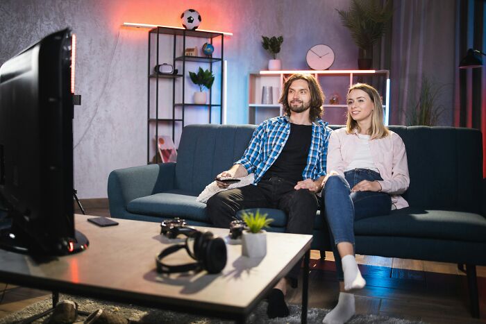 A couple sitting on a couch watching TV together, enjoying a good trend that slowly disappeared over time.