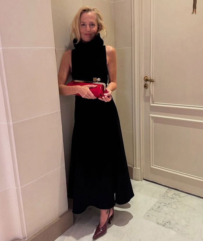 Woman in a black dress holding a red clutch indoors, related to Matthew McConaughey and Emma Roberts viral clip. Woman in a black dress holding a red clutch indoors, related to Matthew McConaughey and Emma Roberts viral clip.