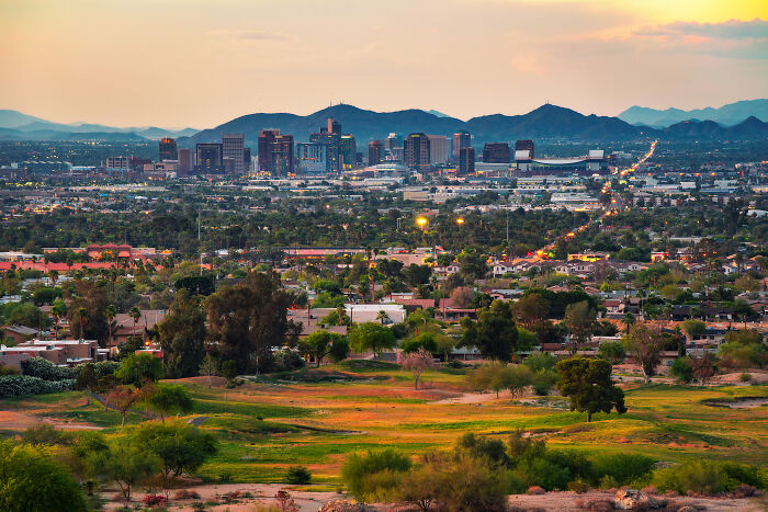 City skyline at sunset with natural landscape foreground, highlighting local dangers in everyday life for residents.