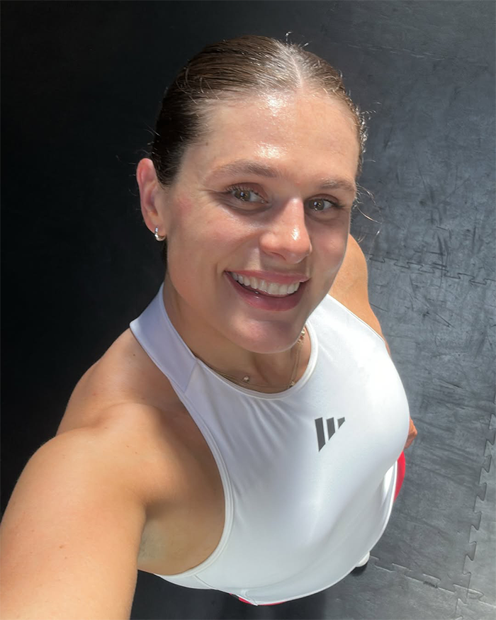 Olympic star smiling in athletic wear, capturing a selfie after a workout, highlighting confidence and strength. Olympic star smiling in athletic wear, capturing a selfie after a workout, highlighting confidence and strength.