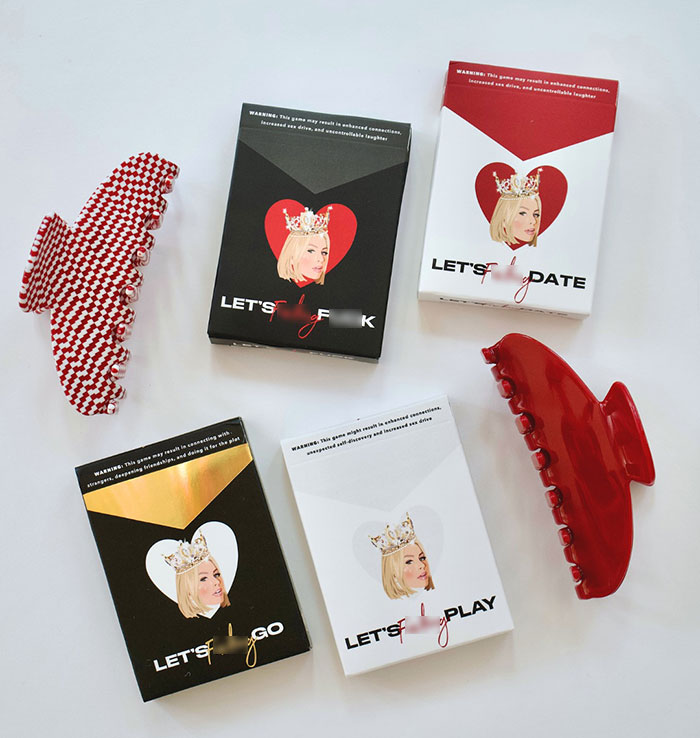 Boxes of a bold card game featuring a crowned woman’s face with heart motifs, related to pushy influencer rejection. Boxes of a bold card game featuring a crowned woman’s face with heart motifs, related to pushy influencer rejection.