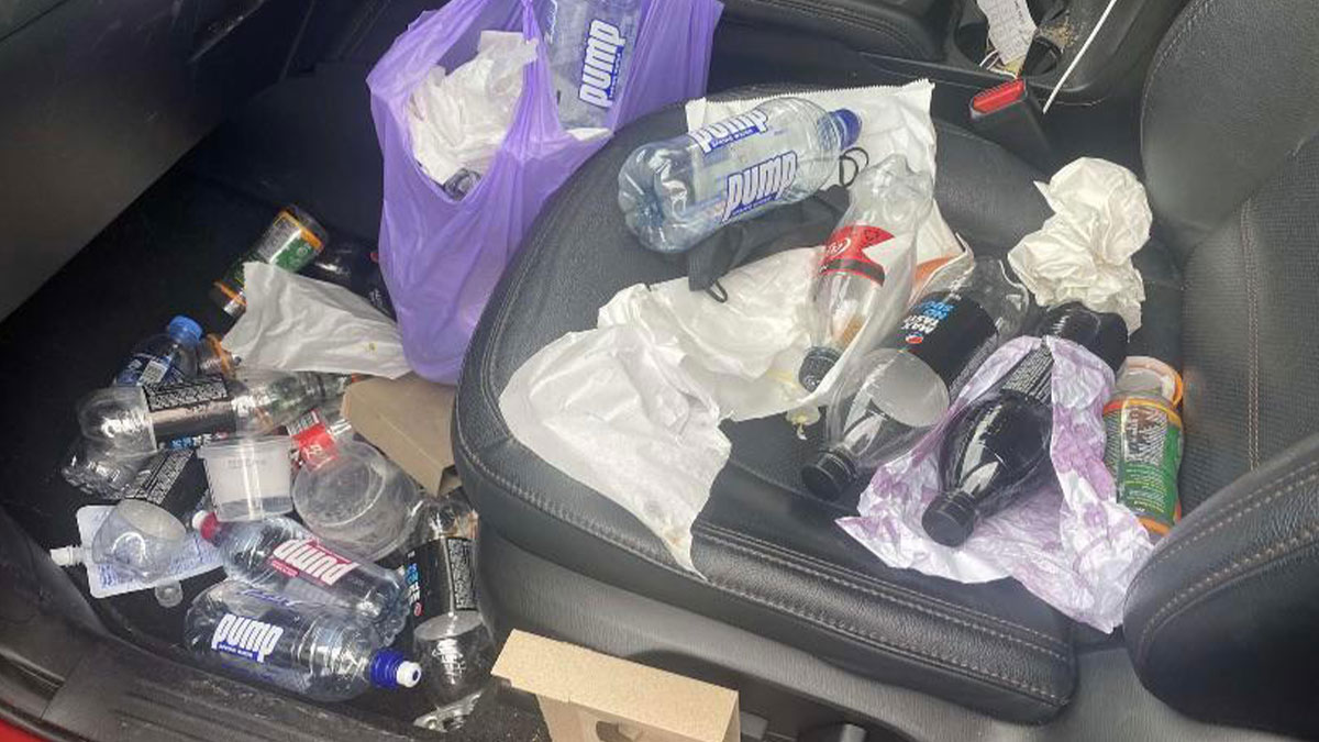 Messy car interior filled with trash and empty bottles showing damage caused by people borrowing and neglecting items.