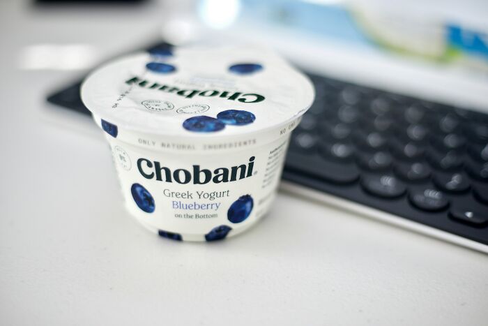 Blueberry Greek yogurt cup placed near a keyboard, representing best processed foods for weight loss. Blueberry Greek yogurt cup placed near a keyboard, representing best processed foods for weight loss.