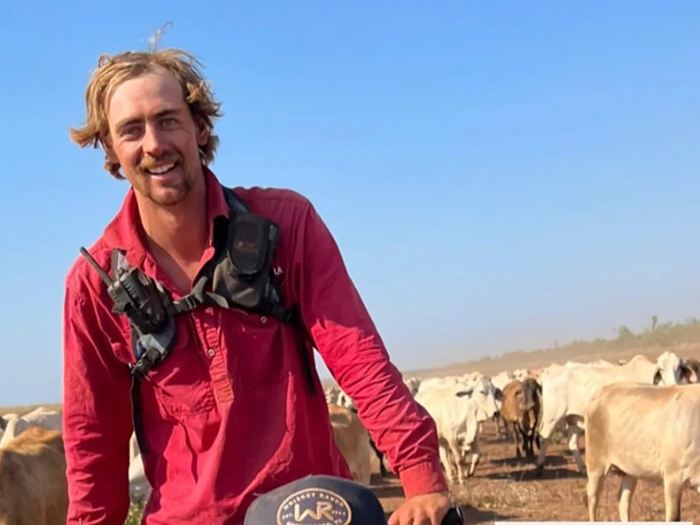 Man in red shirt standing in a field with cattle, related to woman who set male friend on fire case. Man in red shirt standing in a field with cattle, related to woman who set male friend on fire case.