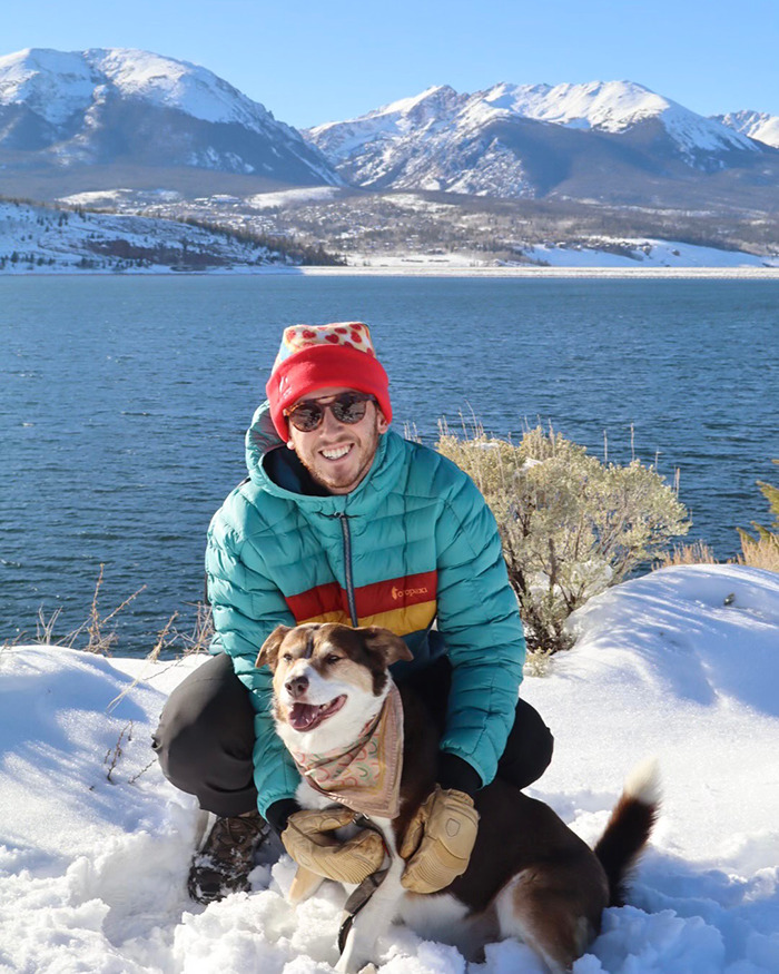 Man wearing winter clothing with dog by snowy lakeside, reflecting a newlywed’s honeymoon tragedy near ankle-deep water. Man wearing winter clothing with dog by snowy lakeside, reflecting a newlywed’s honeymoon tragedy near ankle-deep water.