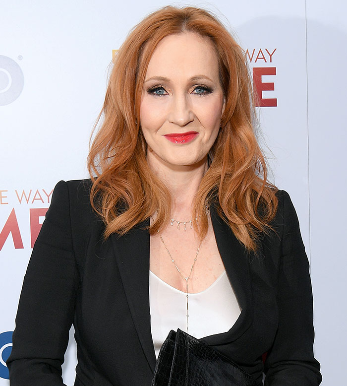 J.K. Rowling at an event, wearing a black blazer and white top, with red hair and a confident smile. J.K. Rowling at an event, wearing a black blazer and white top, with red hair and a confident smile.