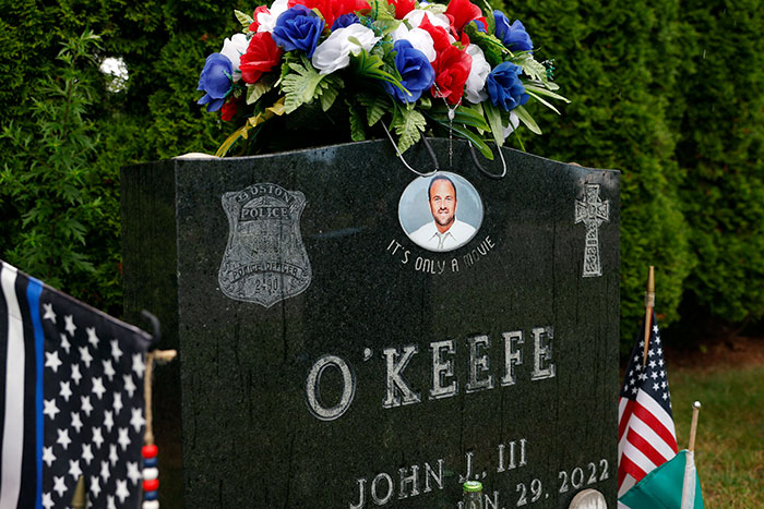 Gravestone of Boston police officer John O’Keefe with flowers and flags, related to Karen Read acquittal trial. Gravestone of Boston police officer John O’Keefe with flowers and flags, related to Karen Read acquittal trial.