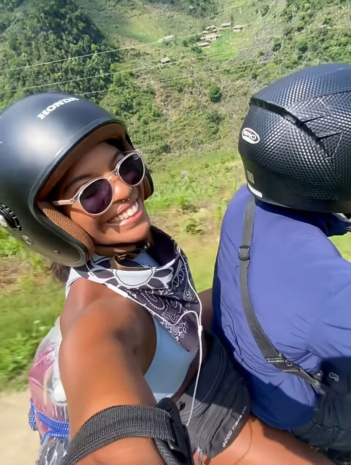 Female tourist wearing helmet and sunglasses enjoying a ride before hiking on an Indonesian volcano.