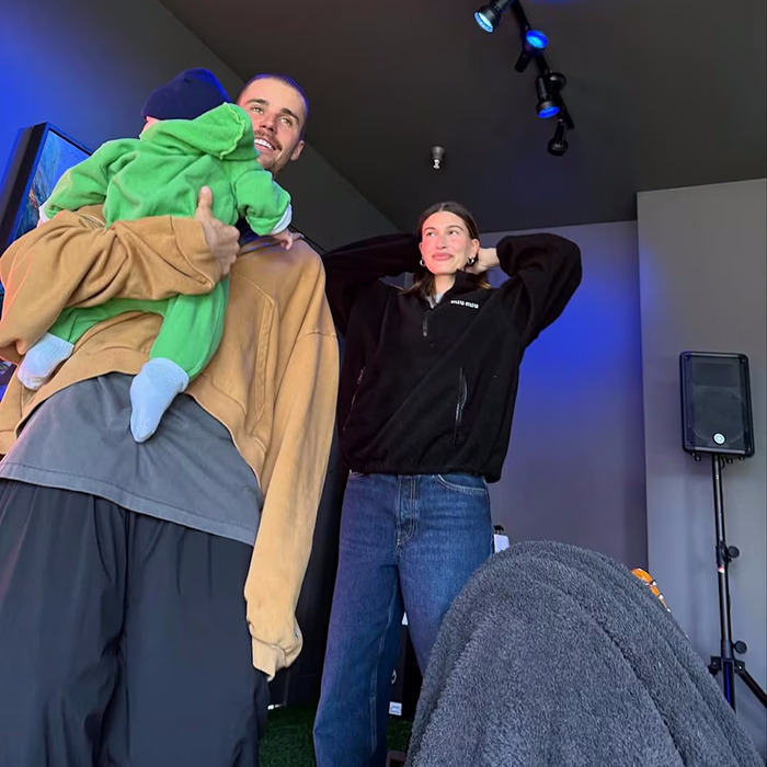 Justin Bieber holding a child indoors with a woman nearby, reflecting on sad confession after aggressive meltdown at paparazzi. Justin Bieber holding a child indoors with a woman nearby, reflecting on sad confession after aggressive meltdown at paparazzi.