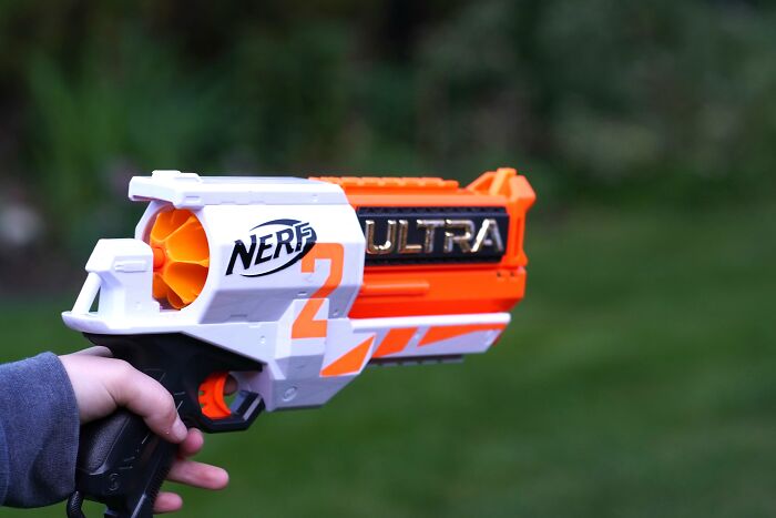 Person holding Nerf gun outdoors illustrating 28 dates that went sour needing a bar safe word for safety.