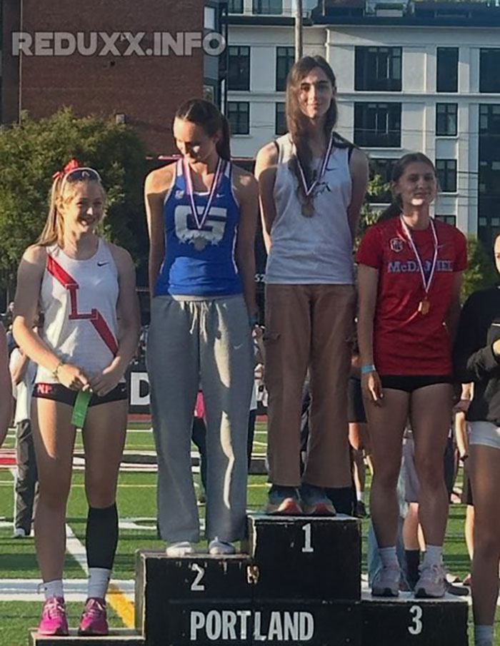 Transgender athlete standing on the podium with medals while cisgender rivals refuse to share the stage during the event. Transgender athlete standing on the podium with medals while cisgender rivals refuse to share the stage during the event.