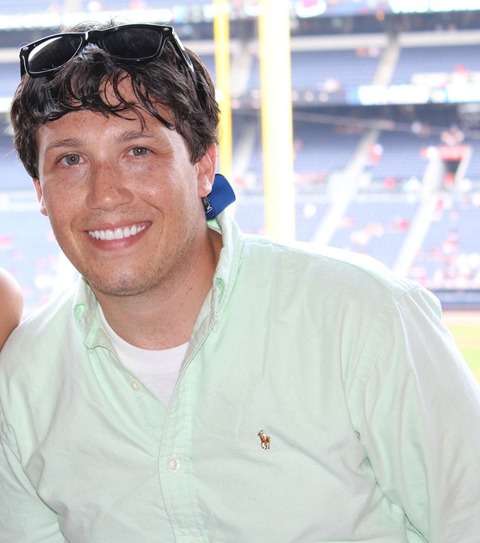 Man smiling in a light green shirt at a sports stadium, related to chiropractor neck pain and locked-in syndrome story. Man smiling in a light green shirt at a sports stadium, related to chiropractor neck pain and locked-in syndrome story.