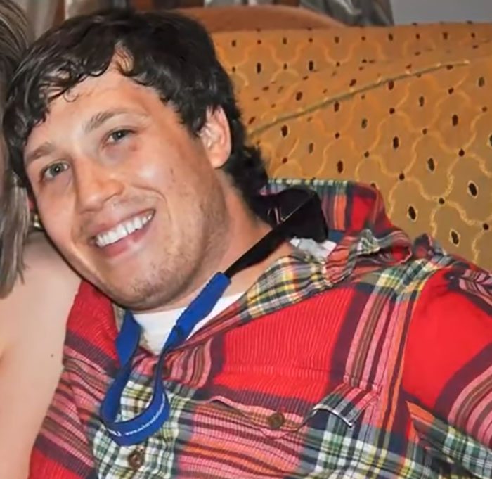 Smiling man in a red plaid shirt sitting, related to chiropractor visit and locked-in syndrome after neck pain treatment. Smiling man in a red plaid shirt sitting, related to chiropractor visit and locked-in syndrome after neck pain treatment.