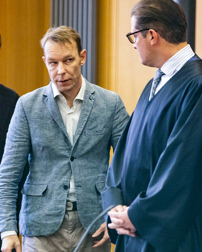 Two men in courtroom attire engaged in a serious discussion related to Madeleine McCann mystery clothing and bones discovery. Two men in courtroom attire engaged in a serious discussion related to Madeleine McCann mystery clothing and bones discovery.