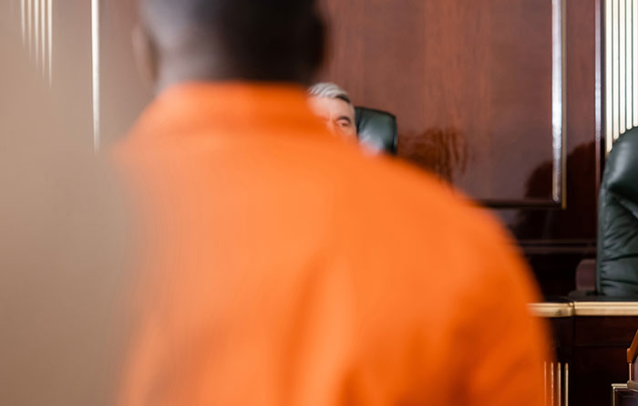 Courtroom scene with a person in an orange jumpsuit and a judge in the background for Diddy court sketch artist coverage. Courtroom scene with a person in an orange jumpsuit and a judge in the background for Diddy court sketch artist coverage.