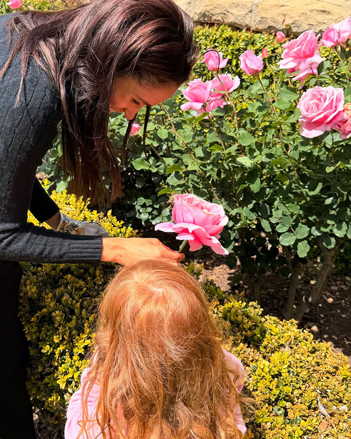 Woman and child tending pink roses in a garden, related to Meghan Markle's twerking pregnancy video controversy. Woman and child tending pink roses in a garden, related to Meghan Markle's twerking pregnancy video controversy.