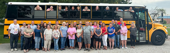 Group of teachers posing in front of a school bus during a White House class trip amid controversial t-shirt issue. Group of teachers posing in front of a school bus during a White House class trip amid controversial t-shirt issue.