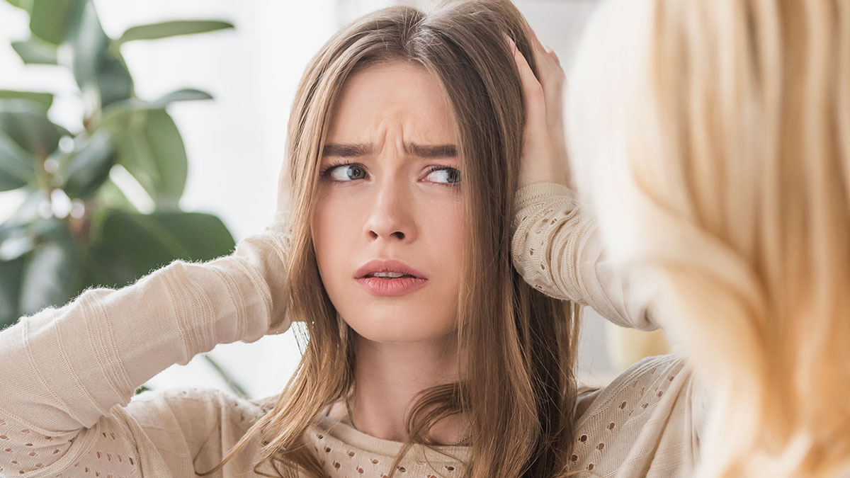 Young daughter-in-law looking upset and frustrated while interacting with mother-in-law indoors, family relationship tension concept.