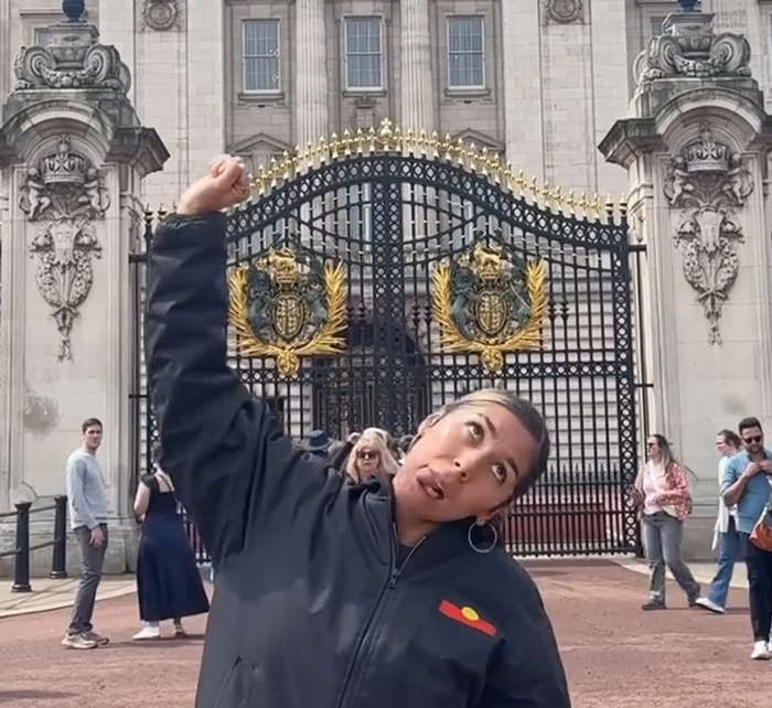 Aboriginal artist performing a provocative song at Buckingham Palace gates, sparking debate about King Charles. Aboriginal artist performing a provocative song at Buckingham Palace gates, sparking debate about King Charles.