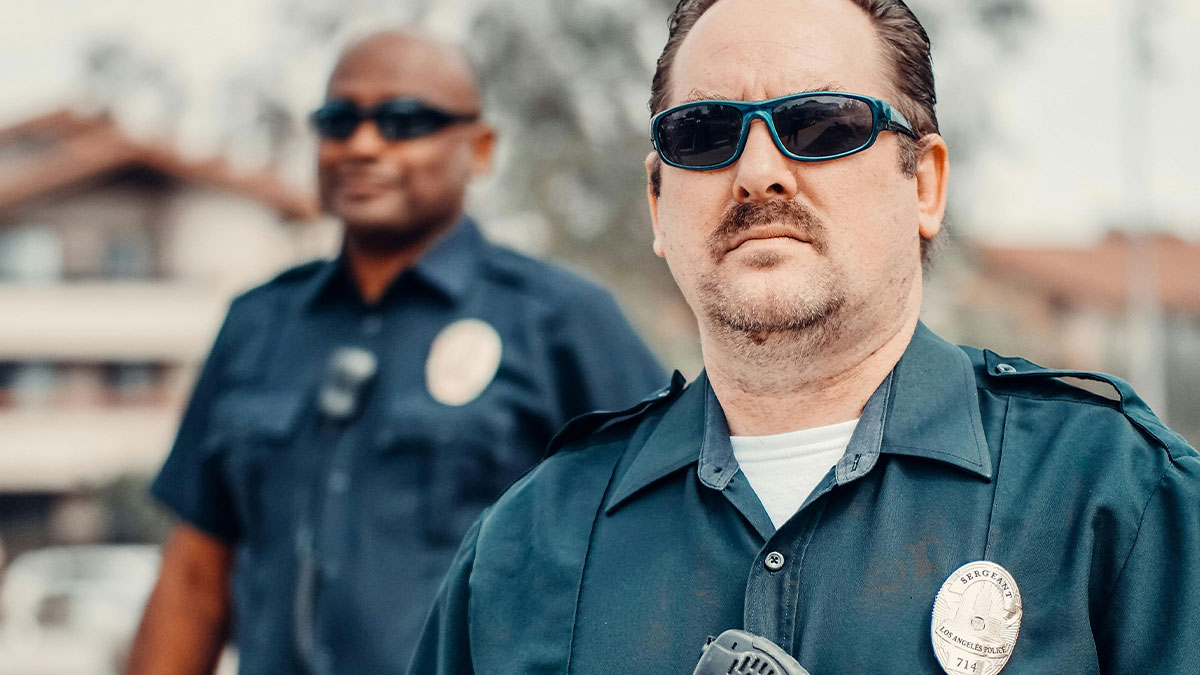 Two police officers wearing sunglasses and uniform standing outdoors, related to dad CPS called playground incident.