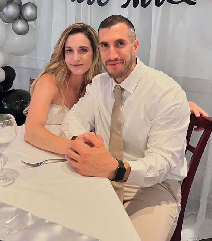 Woman and man sitting at a table, related to a woman complaining about Disney staff scolding her for inappropriate outfit. Woman and man sitting at a table, related to a woman complaining about Disney staff scolding her for inappropriate outfit.