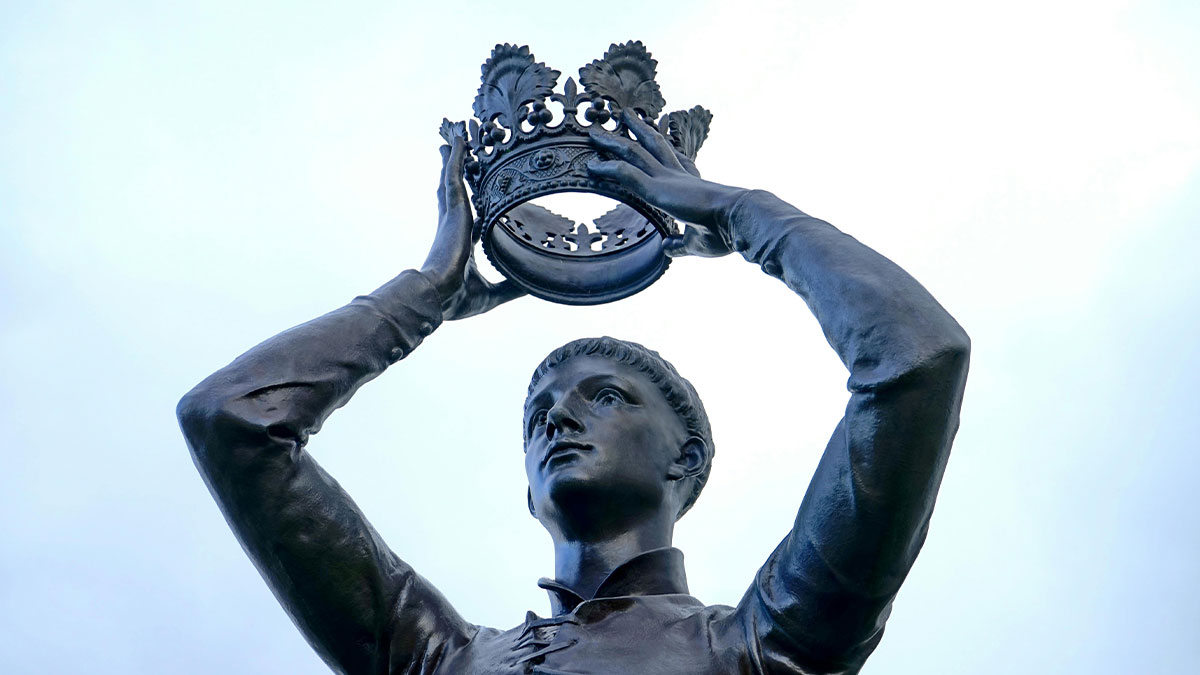 Bronze statue of a young man holding an ornate crown above his head, symbolizing power in one Mississippi counting countries.