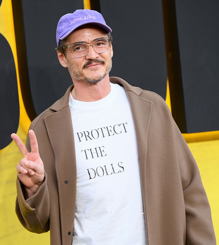 Pedro Pascal wearing a brown coat and purple cap, posing with a peace sign at a public event defending JK Rowling criticism. Pedro Pascal wearing a brown coat and purple cap, posing with a peace sign at a public event defending JK Rowling criticism.
