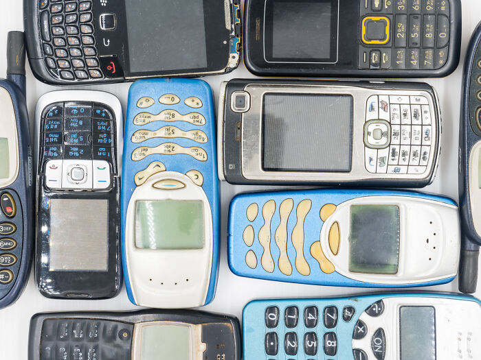 Old mobile phones and vintage tech devices showcasing skills people online needed before the 2000s.