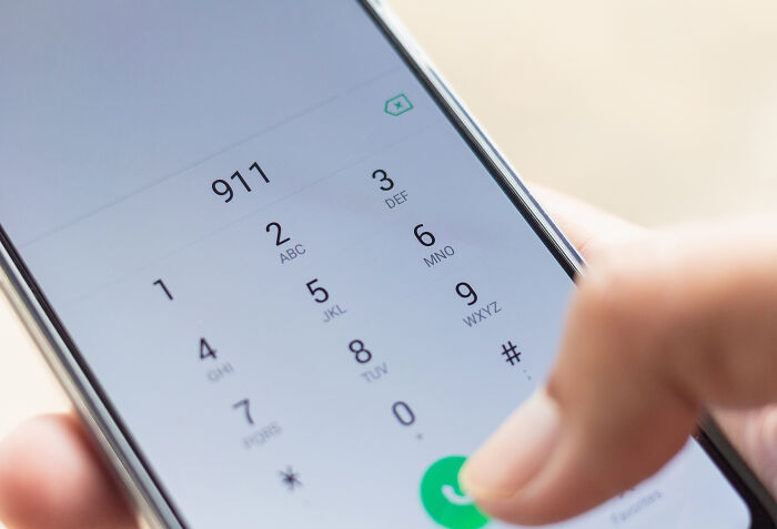 Close-up of a smartphone dialer with 911 entered, highlighting skills people online needed before the 2000s but no longer use.