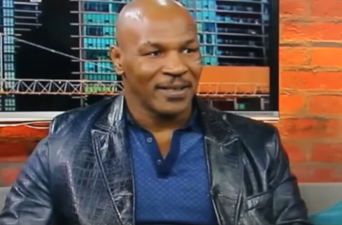 Man in a black leather jacket and blue shirt speaking in an indoor interview about skills people needed online before the 2000s