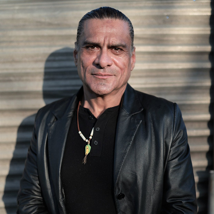 Man wearing a black leather jacket and necklace standing outdoors, related to Chris Pratt sparks heated reactions topic. Man wearing a black leather jacket and necklace standing outdoors, related to Chris Pratt sparks heated reactions topic.