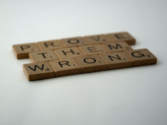 Wooden Scrabble tiles arranged to spell prove them wrong, illustrating a rebus puzzle challenge for smart thinkers. Wooden Scrabble tiles arranged to spell prove them wrong, illustrating a rebus puzzle challenge for smart thinkers.