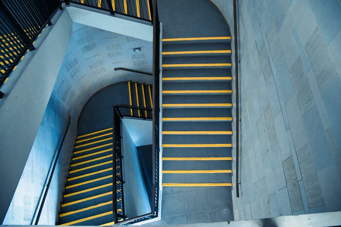 Spiral staircase with yellow-striped steps, symbolizing a journey or path, related to theories about the afterlife.