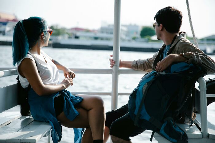 A wife and husband sitting on a boat, enjoying a scenic view, symbolizing priceless rewards and shared moments.