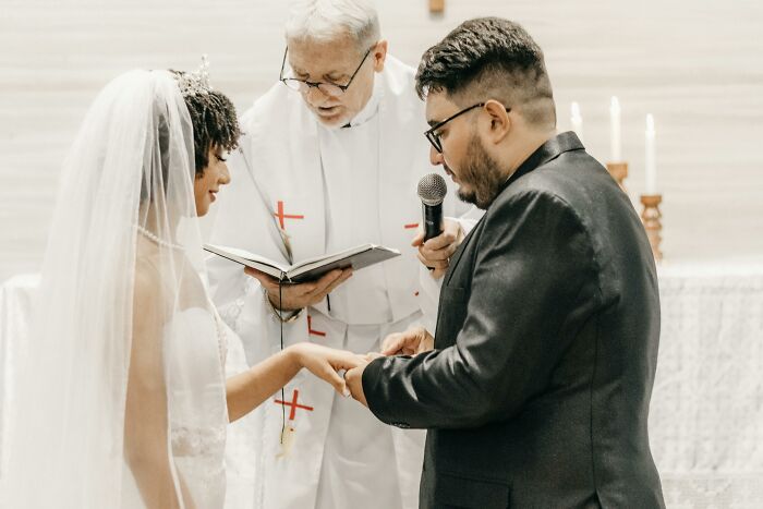 Bride and groom exchanging rings during a wedding ceremony, symbolizing commitment and life-changing moments.