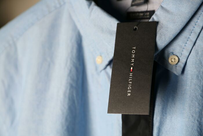 Light blue Tommy Hilfiger shirt with tag, representing relatable flags associated with middle class style.