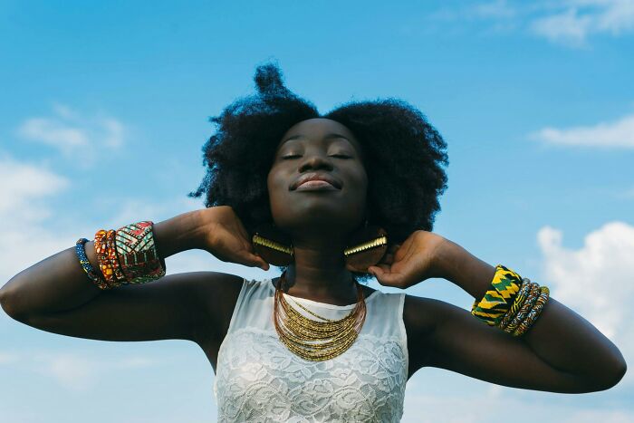 Young woman with afro hairstyle wearing colorful bracelets and necklace.