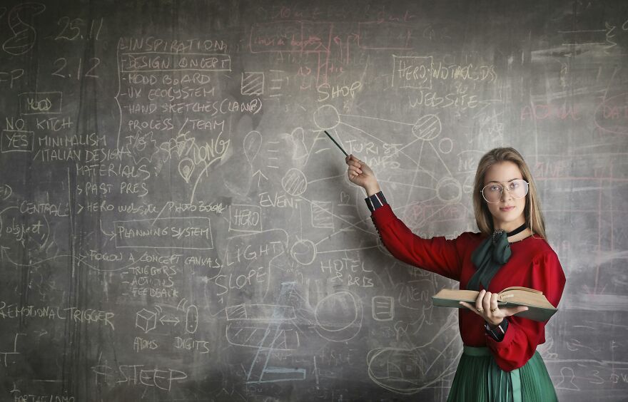 Woman explaining quirky facts in a surprising trivia quiz written on a chalkboard in a classroom setting. Woman explaining quirky facts in a surprising trivia quiz written on a chalkboard in a classroom setting.