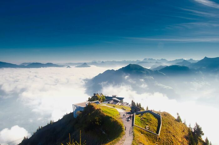 Scenic mountain viewpoint above clouds with people enjoying the view symbolizing privileged moments shared outdoors.