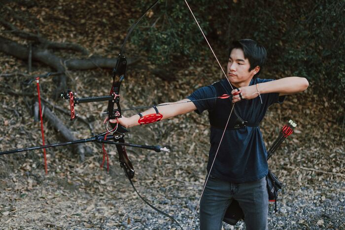 Adult practicing archery outdoors, showing skills that reflect their high school glory days and passion for the sport.