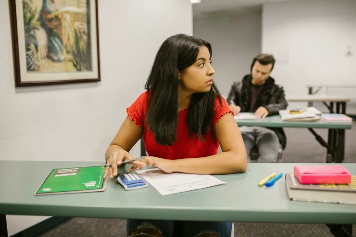 Young adult in a classroom looking distracted, illustrating adults who never moved on from their high school glory days.