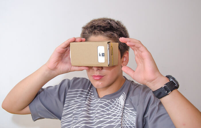 Boy using a cardboard virtual reality headset, illustrating a priceless reward experience after spending just a dollar.